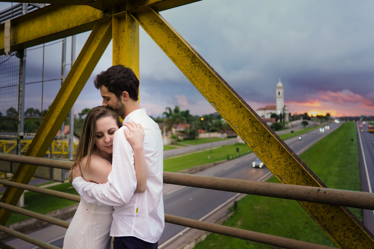 Ensaio de casamento do casal Camila e Guto fotografado pelo fotógrafo Michel Druziki em Campo Largo. Casal abraçado em cima da passarela