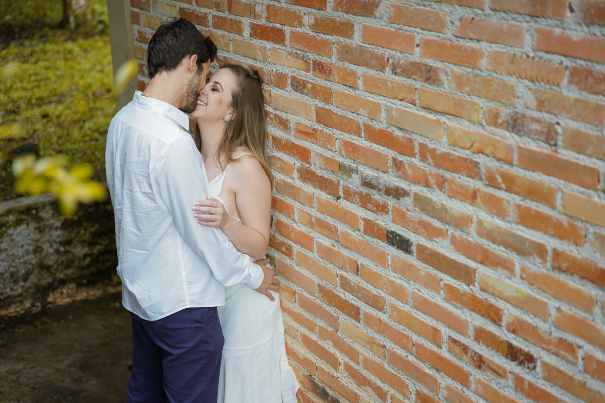 Ensaio de casamento do casal Camila e Guto fotografado pelo fotógrafo Michel Druziki em Campo Largo. Noivos encostados na parede e sorrindo