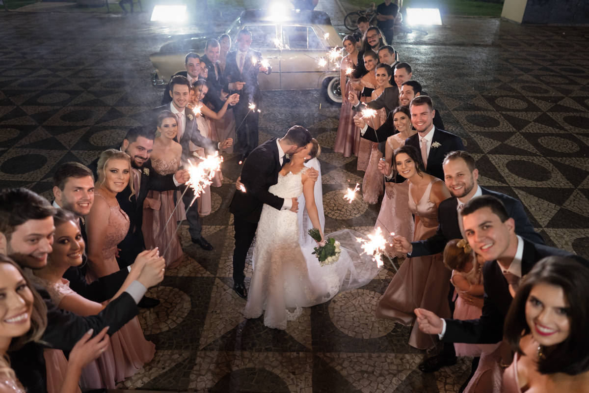 Casamento da Camila e Guto na igreja Matriz de Campo Largo, fotografado pelo melhor fotógrafo de casamentos em Campo Largo e Curitiba, Michel Druziki. Noivos se beijando cercados de padrinhos e madrinhas