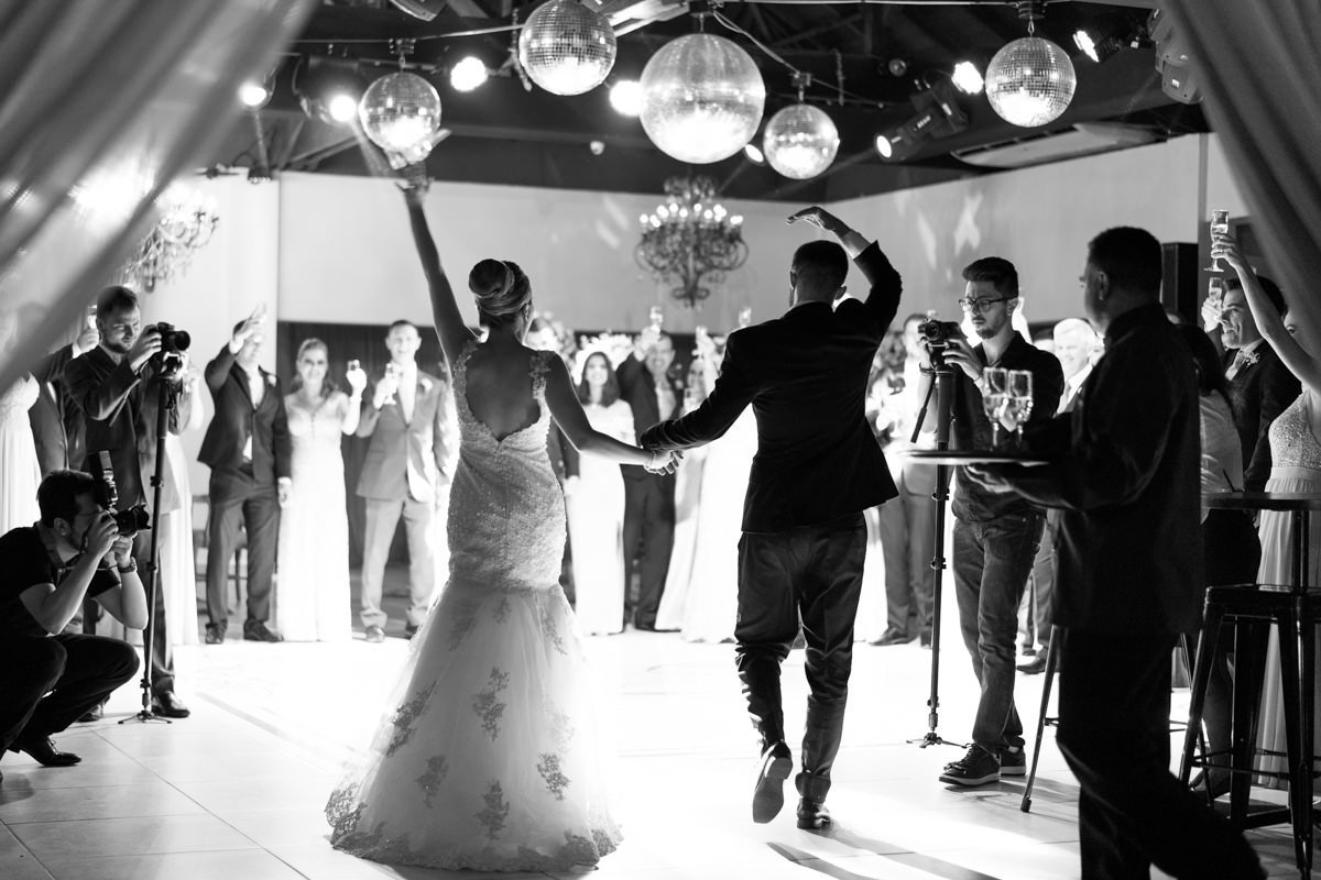 Casamento da Camila e Guto na igreja Matriz de Campo Largo, fotografado pelo melhor fotógrafo de casamentos em Campo Largo e Curitiba, Michel Druziki. Noivos chegando na festa de mãos dadas