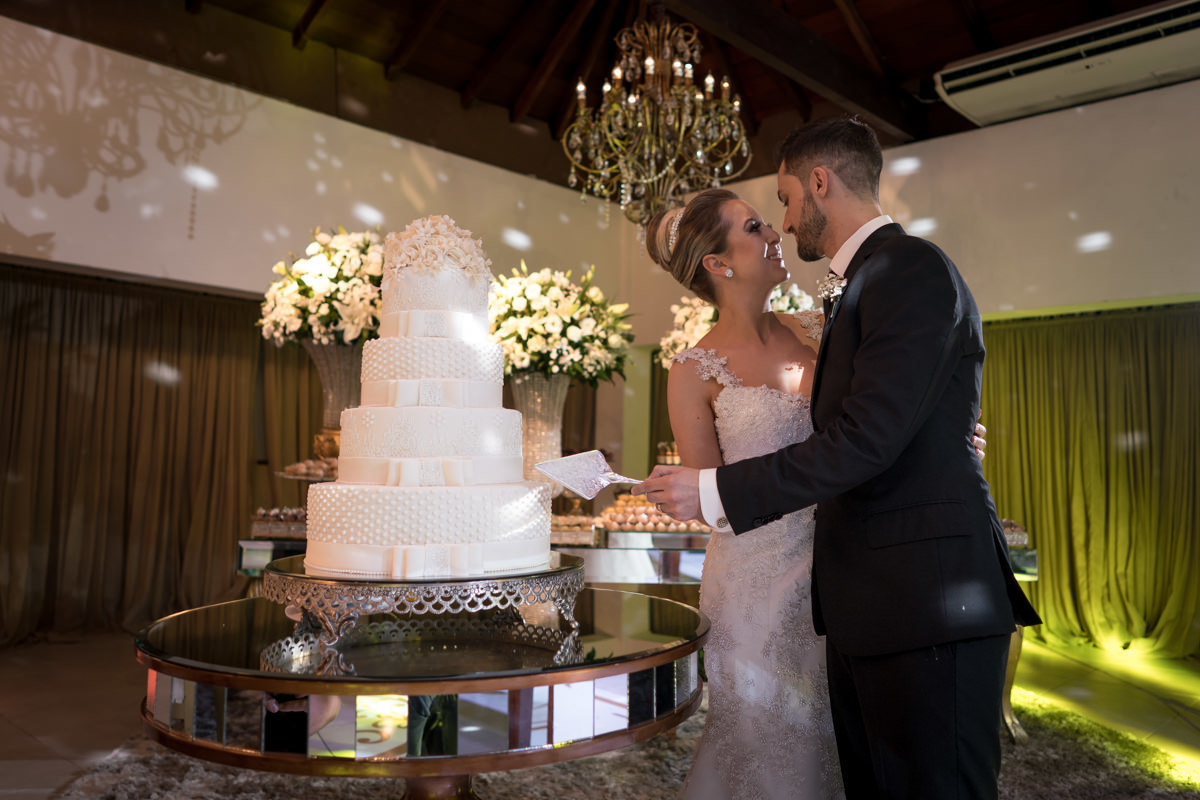 Casamento da Camila e Guto na igreja Matriz de Campo Largo, fotografado pelo melhor fotógrafo de casamentos em Campo Largo e Curitiba, Michel Druziki. Noivos cortando bolo de casamento