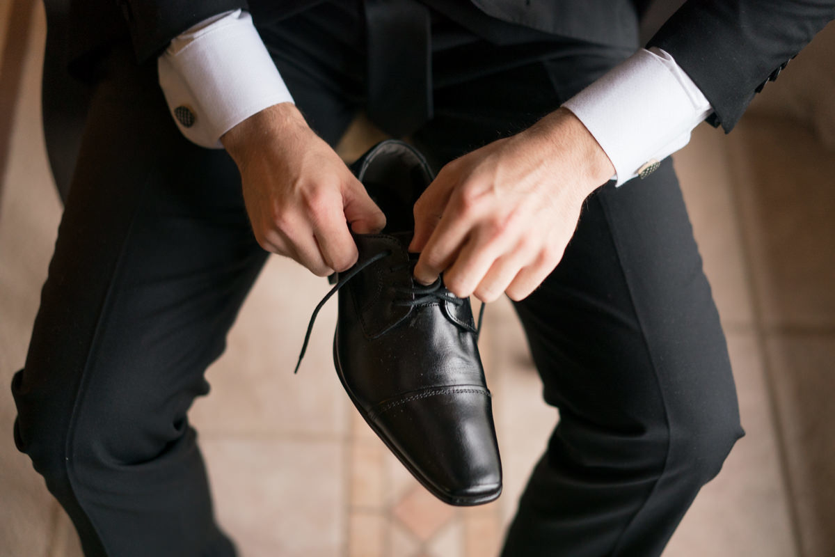 Making of no salão Camaleão cabelo e estética, do lindo casamento da Camila e Guto, fotografado pelo fotógrafo de casamentos em Campo Largo e Curitiba, Michel Druziki. 
Noivo colocando os sapatos