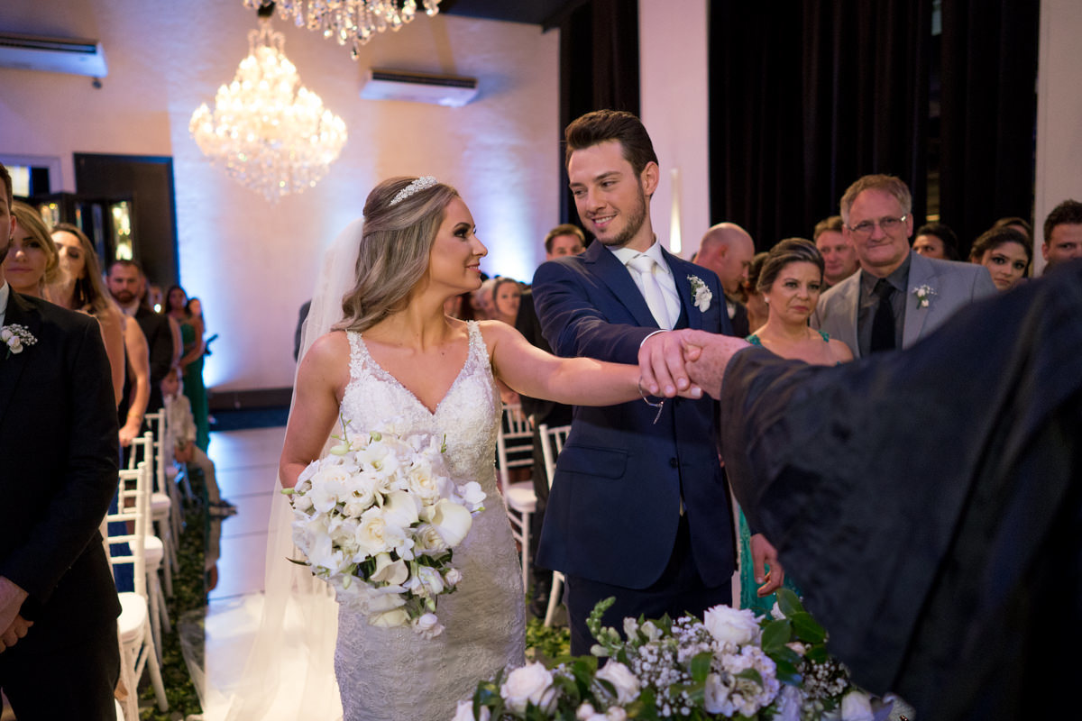 Casamento sofisticado da Thauana e Lucas, no Indra Catering em Curitiba, fotografado pelo fotógrafo de casamentos em Campo Largo e Curitiba, Michel Druziki. Noivos com as mãos juntas e se olhando 