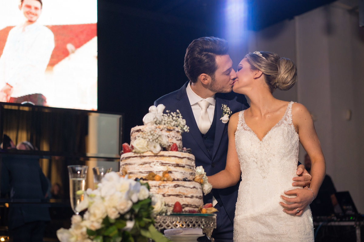 Casamento sofisticado da Thauana e Lucas, no Indra Catering em Curitiba, fotografado pelo fotógrafo de casamentos em Campo Largo e Curitiba, Michel Druziki. Noivos cortando os bolos e se beijando