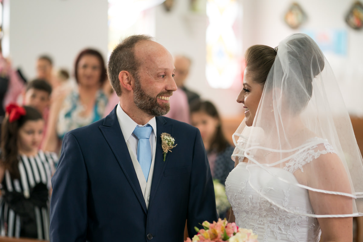 O fotógrafo de casamentos Michel  O fotógrafo de casamentos Michel Druziki, fotografou o casamento lindo do casal Larise e Alexandre, em Curitiba. Noivos se olhando e sorrindo durante a cerimônia