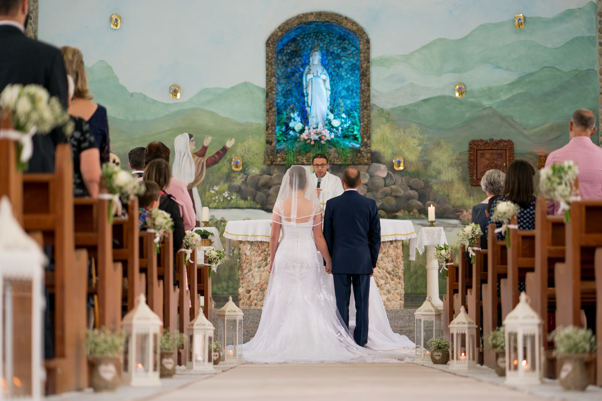  O fotógrafo de casamentos Michel Druziki, fotografou o casamento lindo do casal Larise e Alexandre, em Curitiba. Noivos e convidados vistos da entrada da igreja