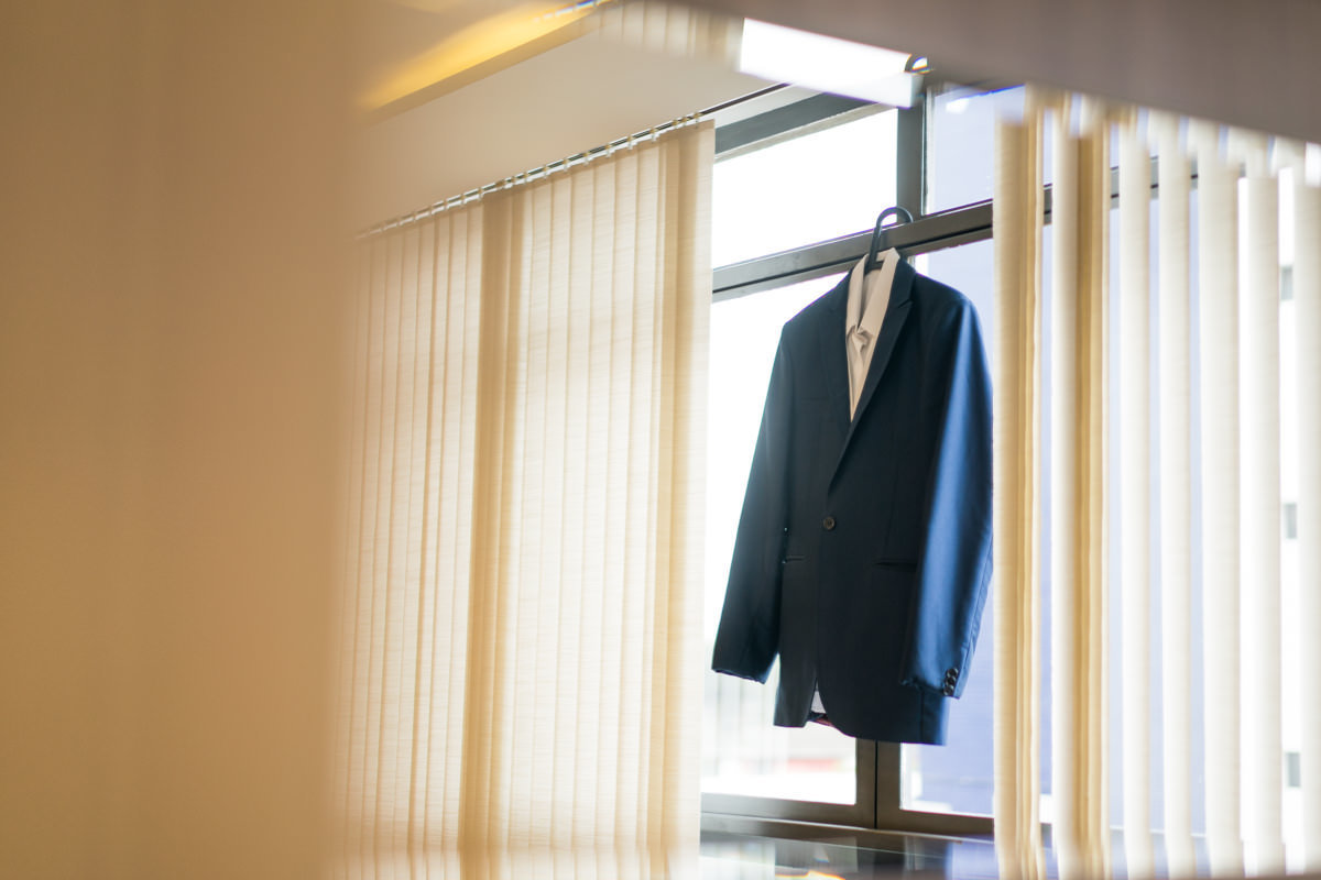 O fotógrafo de casamentos Michel Druziki em Campo Largo e Curitiba, fotografou making of da noiva Larise, no seu apartamento em Curitiba. Paletó do noivo na janela