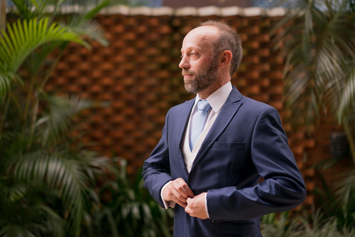 O fotógrafo de casamentos Michel Druziki em Campo Largo e Curitiba, fotografou making of da noiva Larise, no seu apartamento em Curitiba. Noivo abotoando o paletó