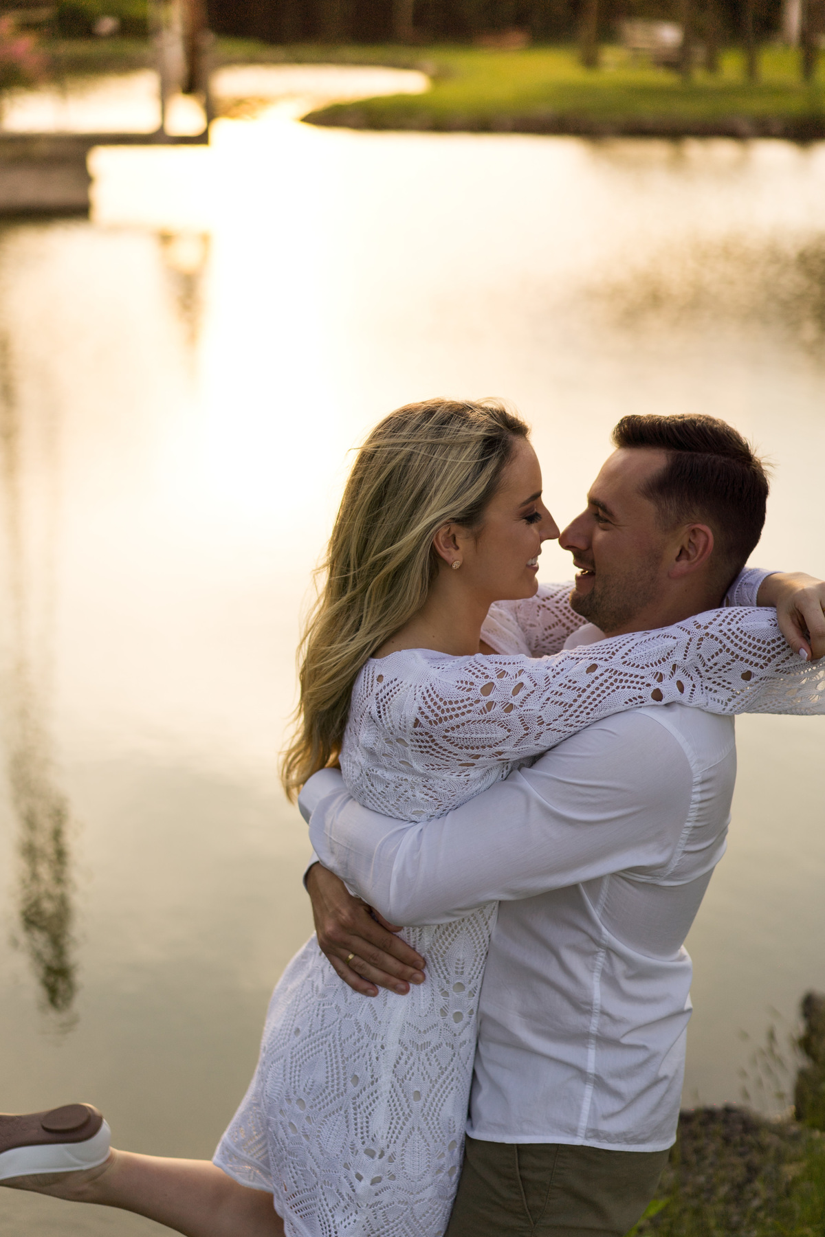 O fotógrafo de casamentos em Campo Largo e Curitiba, Michel Druziki fotografou o casal Ana Maria e Ricardo no Rancho P&R Luxo do Campo em São Luiz do Purunã. Casal sorrindo com nariz encostados em frente ao lago.