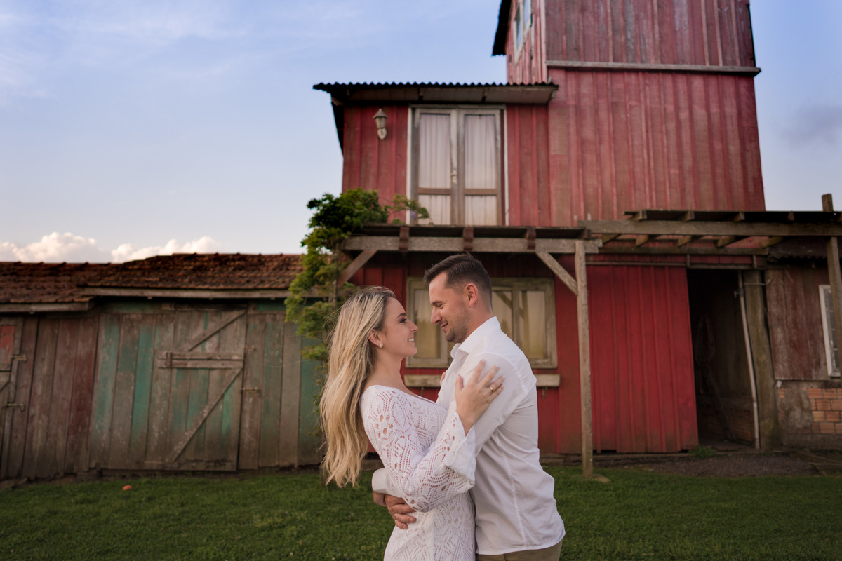 O fotógrafo de casamentos em Campo Largo e Curitiba, Michel Druziki fotografou o casal Ana Maria e Ricardo no Rancho P&R Luxo do Campo em São Luiz do Purunã. Casal sorrindo e se olhando em frente à casinha vermelha.