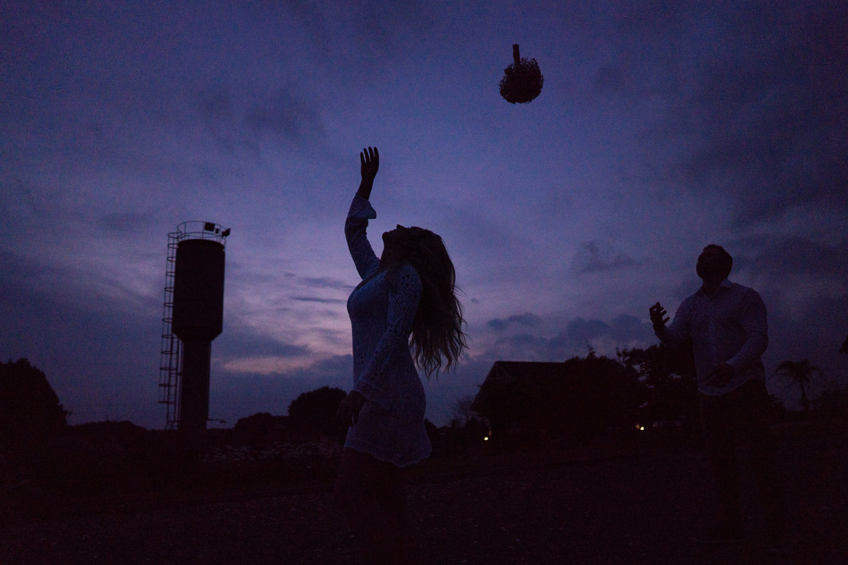O fotógrafo de casamentos em Campo Largo e Curitiba, Michel Druziki fotografou o casal Ana Maria e Ricardo no Rancho P&R Luxo do Campo em São Luiz do Purunã. Noiva de costas jogando buquê de flores para o noivo.