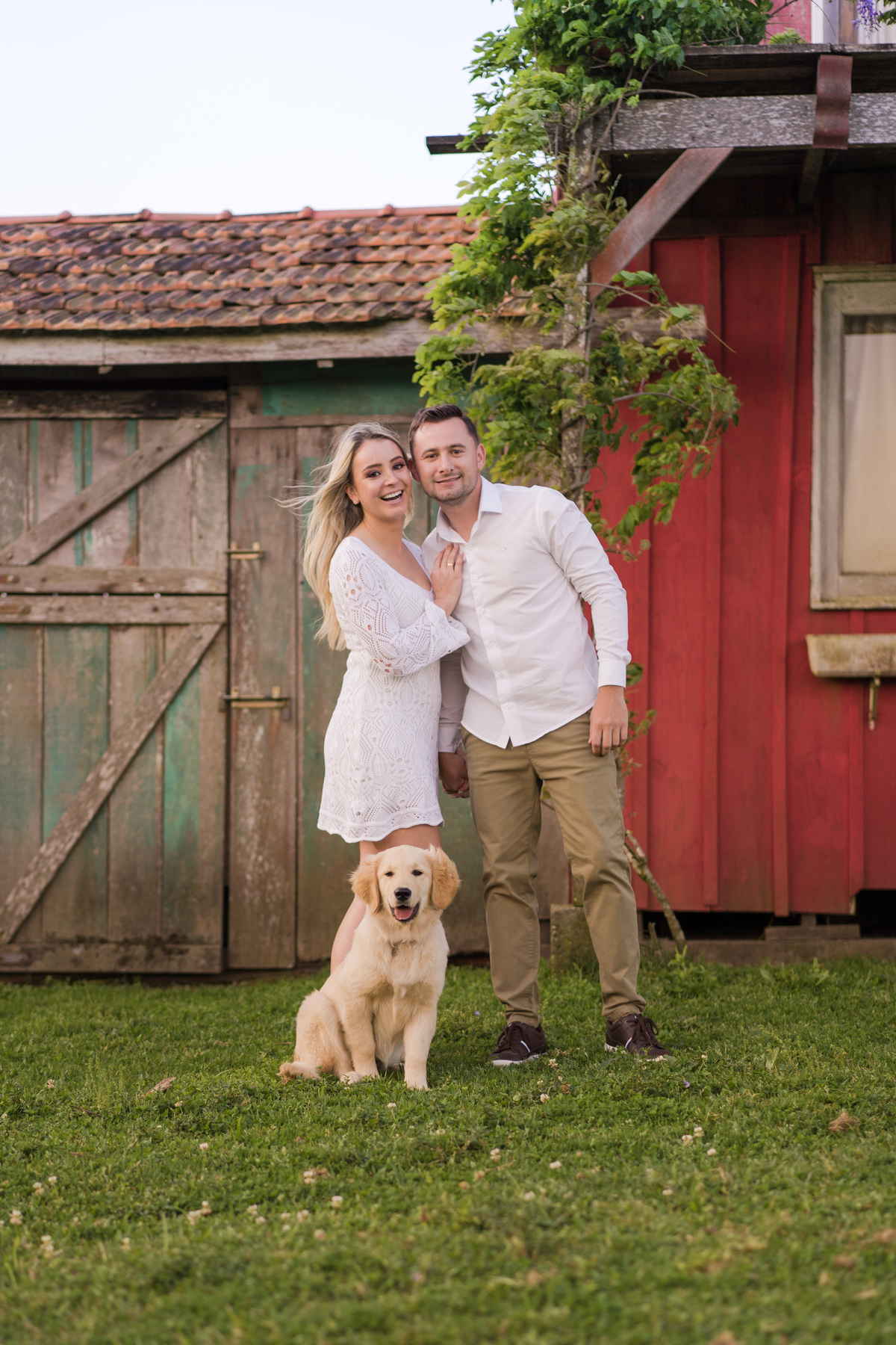 O fotógrafo de casamentos em Campo Largo e Curitiba, Michel Druziki fotografou o casal Ana Maria e Ricardo no Rancho P&R Luxo do Campo em São Luiz do Purunã. Casal sorrindo em frente à casinha vermelha com cachorrinho fofo. 