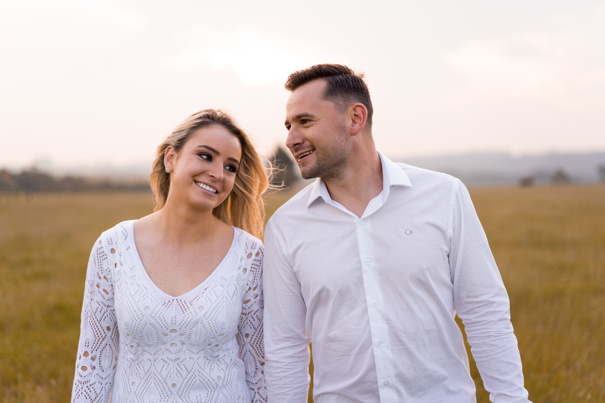 O fotógrafo de casamentos em Campo Largo e Curitiba, Michel Druziki fotografou o casal Ana Maria e Ricardo no Rancho P&R Luxo do Campo em São Luiz do Purunã. Casal de mãos dadas caminhando no campo.