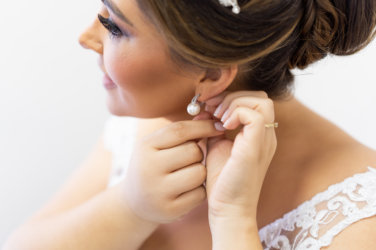 Making of feito pelo fotógrafo de casamento Michel Druziki, no salão Camaleão cabelo e estética, em Campo Largo. Noiva colocando brinco de pérolas.
