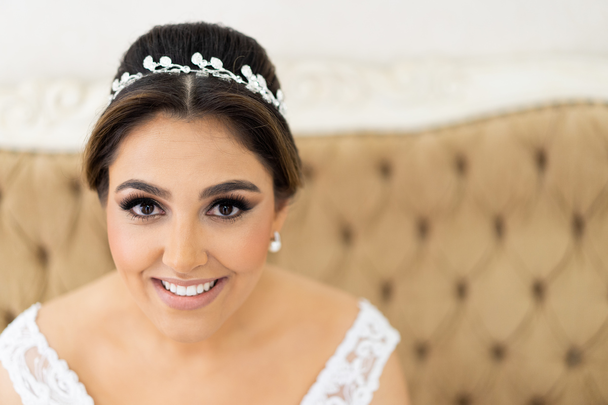 Making of feito pelo fotógrafo de casamento Michel Druziki, no salão Camaleão cabelo e estética, em Campo Largo. Noiva com tiara The Adress Love, sentada e sorrindo 