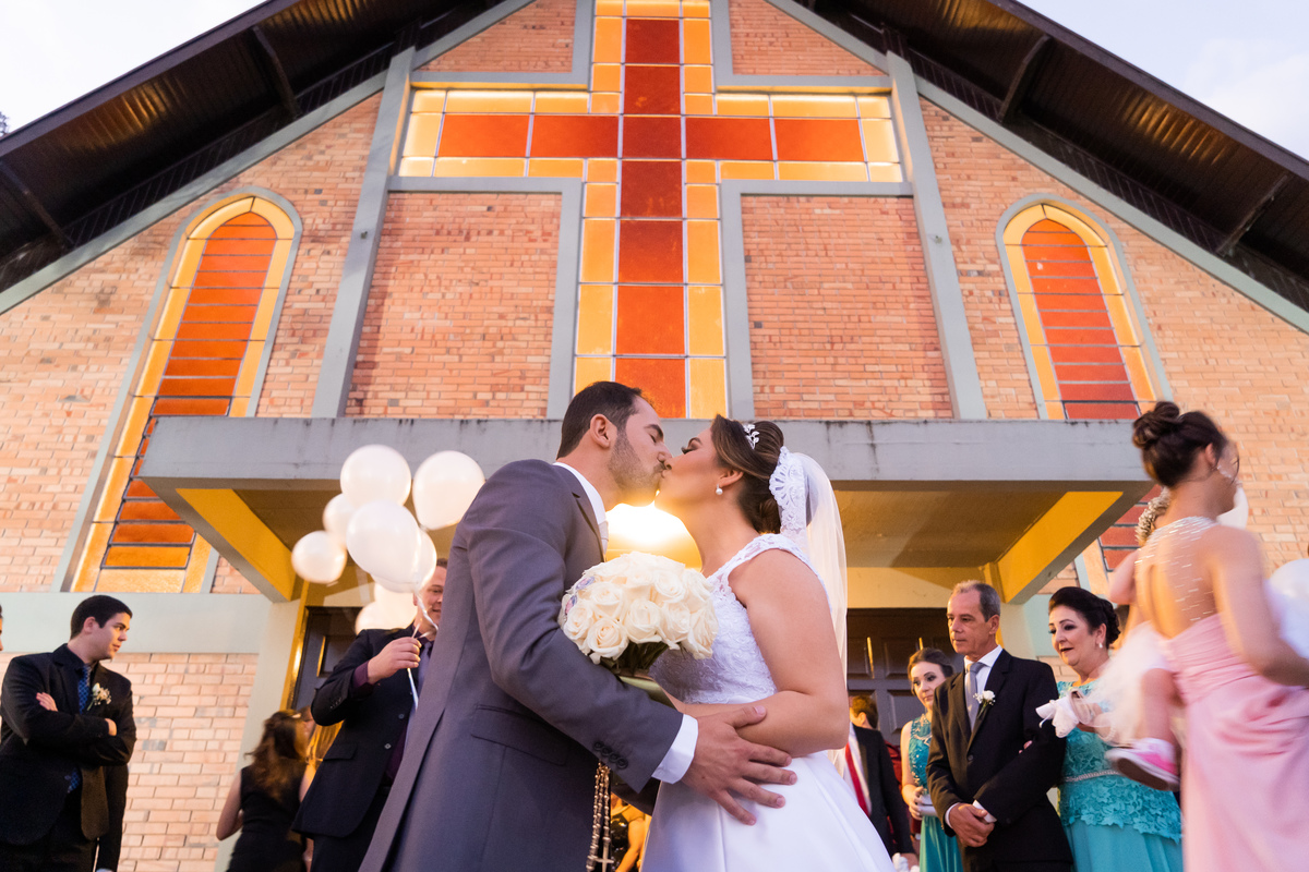 O fotógrafo de casamentos em Campo Largo e Curitiba, Michel Druziki fotografou o casal Debora e Alex Almeida, numa cerimônia cheia de emoção, na igreja São Pedro e São Paulo, em Campo Largo. Noivos se beijando em frente à igreja.