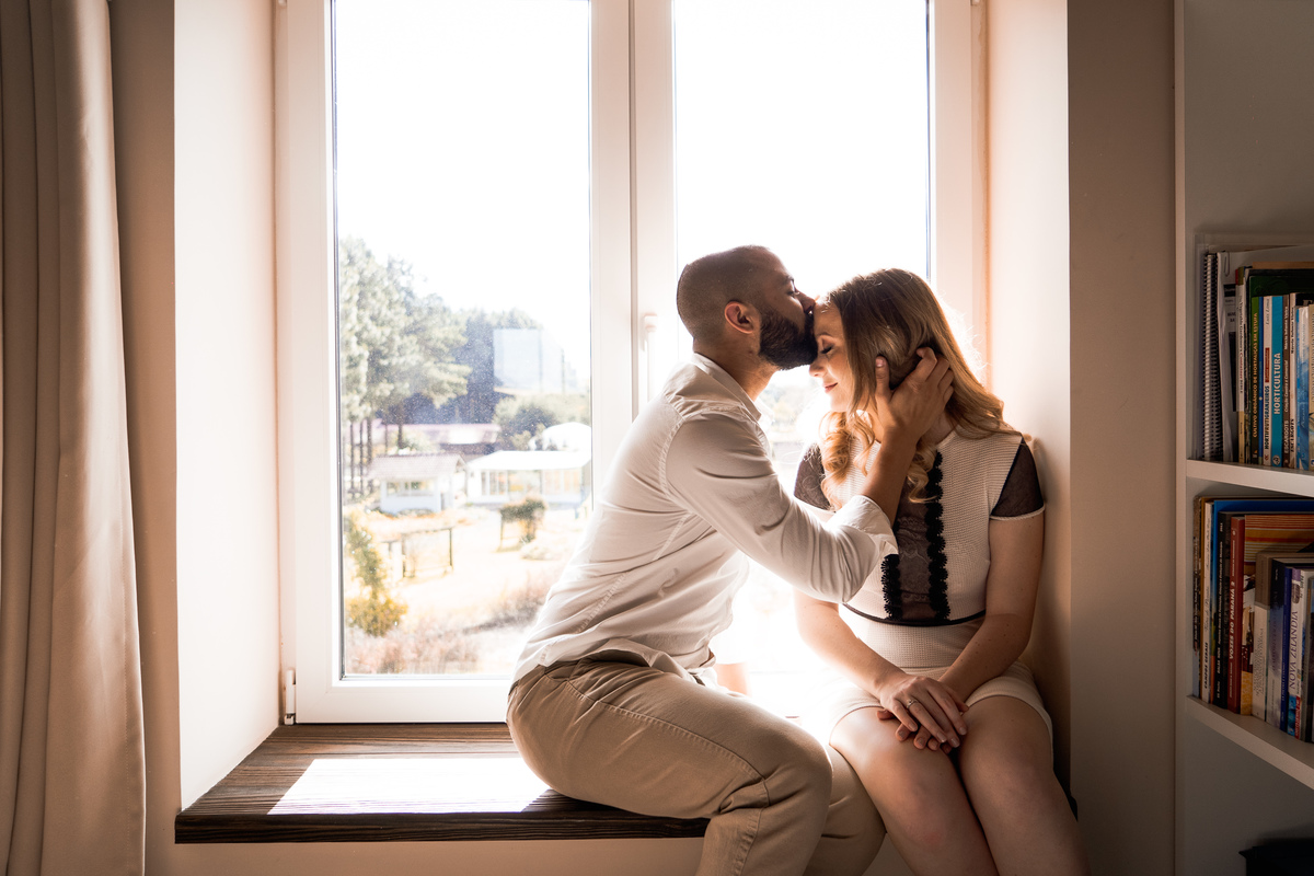 O fotógrafo de casamentos em Campo Largo e Curitiba, Michel Druziki fotografou o casal Daniela e Paulo em uma tarde ensolarada no Rancho P&R, em São Luiz do Purunã. Noivo dando beijo na testa da noiva sentada na janela.