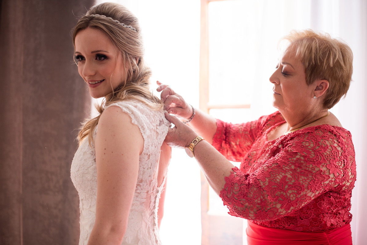 Making of no hotel, feito pelo fotógrafo de casamentos em Campo Largo e Curitiba, Michel Druziki. Casamento Daniela e Paulo, em Curitiba. Mãe da noiva fechando o vestido de casamento.