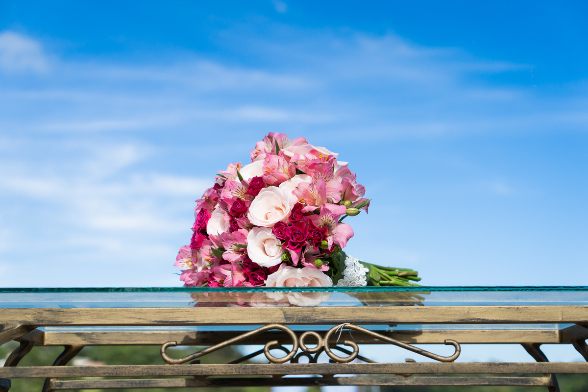 O fotógrafo de casamentos em Campo Largo e Curitiba, Michel Druziki fotografou o casamento de Kaline e Paulo no Espaço Eccos em uma manhã de sábado ensolarada, em Campo Largo. Buquê de flores com céu azul.