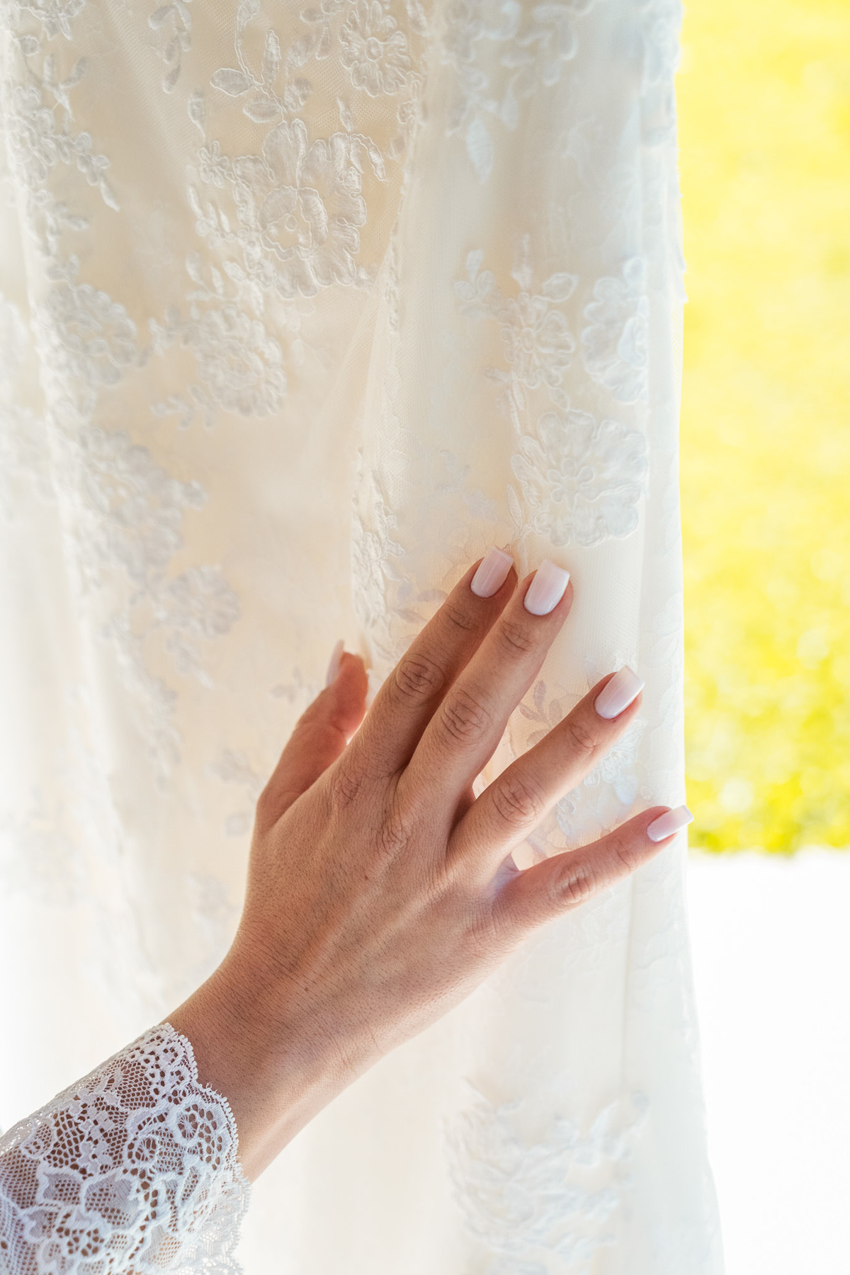 O fotógrafo de casamentos em Campo Largo e Curitiba, Michel Druziki fotografou o casamento de Kaline e Paulo no Espaço Eccos em uma manhã de sábado ensolarada, em Campo Largo. Detalhe mão da noiva no vestido de casamento. Making of. 