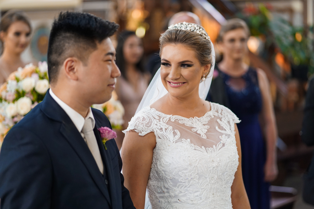Casamento fotografado pelo fotógrafo Michel Druziki. Cerimônia de casamento dos noivos Denise e Marcelo foi realizada na igreja Matriz de Campo Largo. Noiva sorrindo para o noivo dentro da igreja