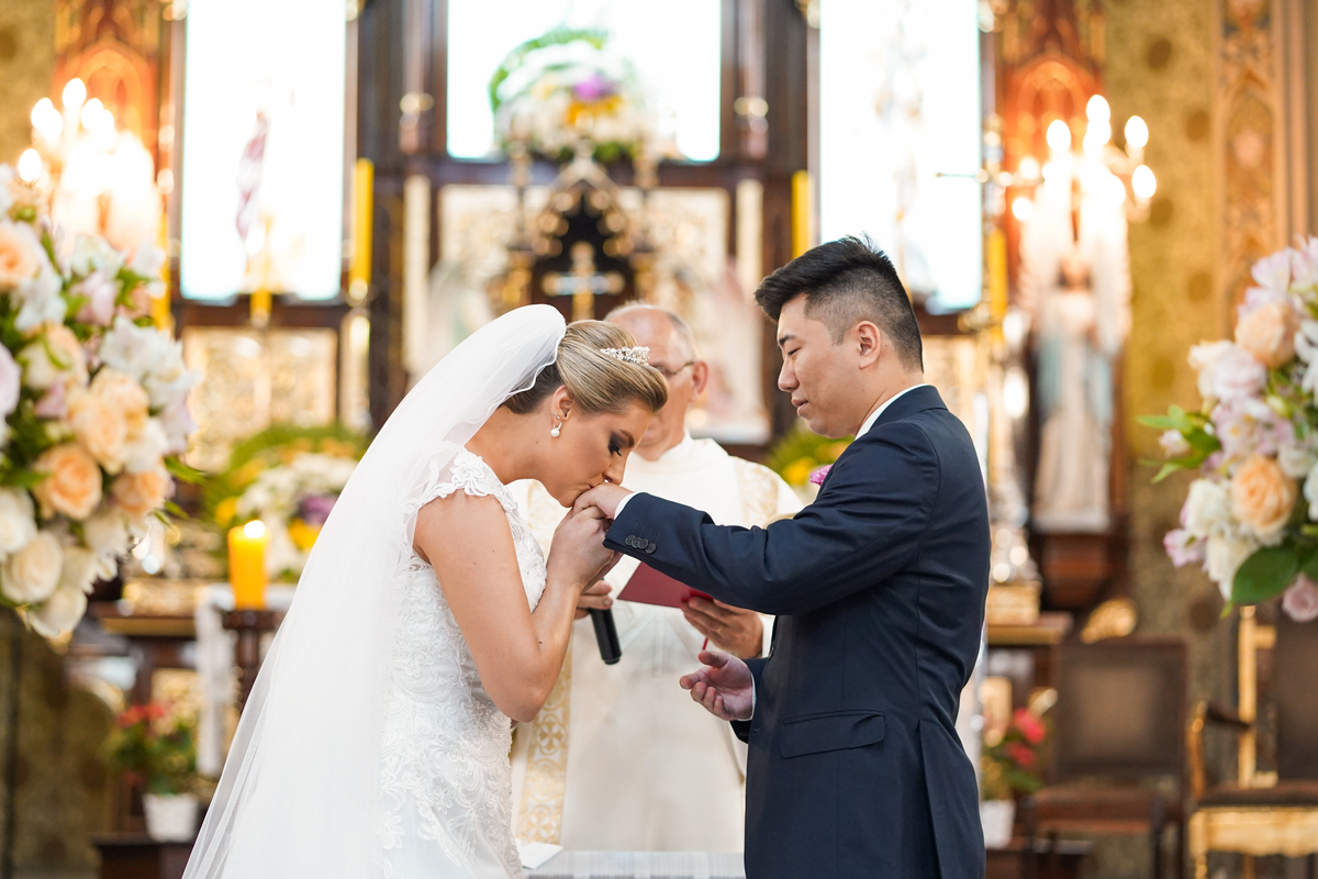 Casamento fotografado pelo fotógrafo Michel Druziki. Cerimônia de casamento dos noivos Denise e Marcelo foi realizada na igreja Matriz de Campo Largo. Noiva beijando a aliança