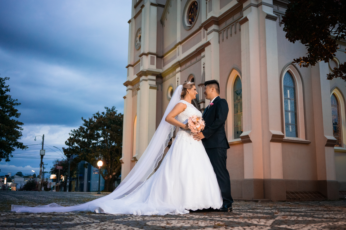 Casamento fotografado pelo fotógrafo Michel Druziki. Cerimônia de casamento dos noivos Denise e Marcelo foi realizada na igreja Matriz de Campo Largo. Noivos abraçados em frente à igreja após o casamento