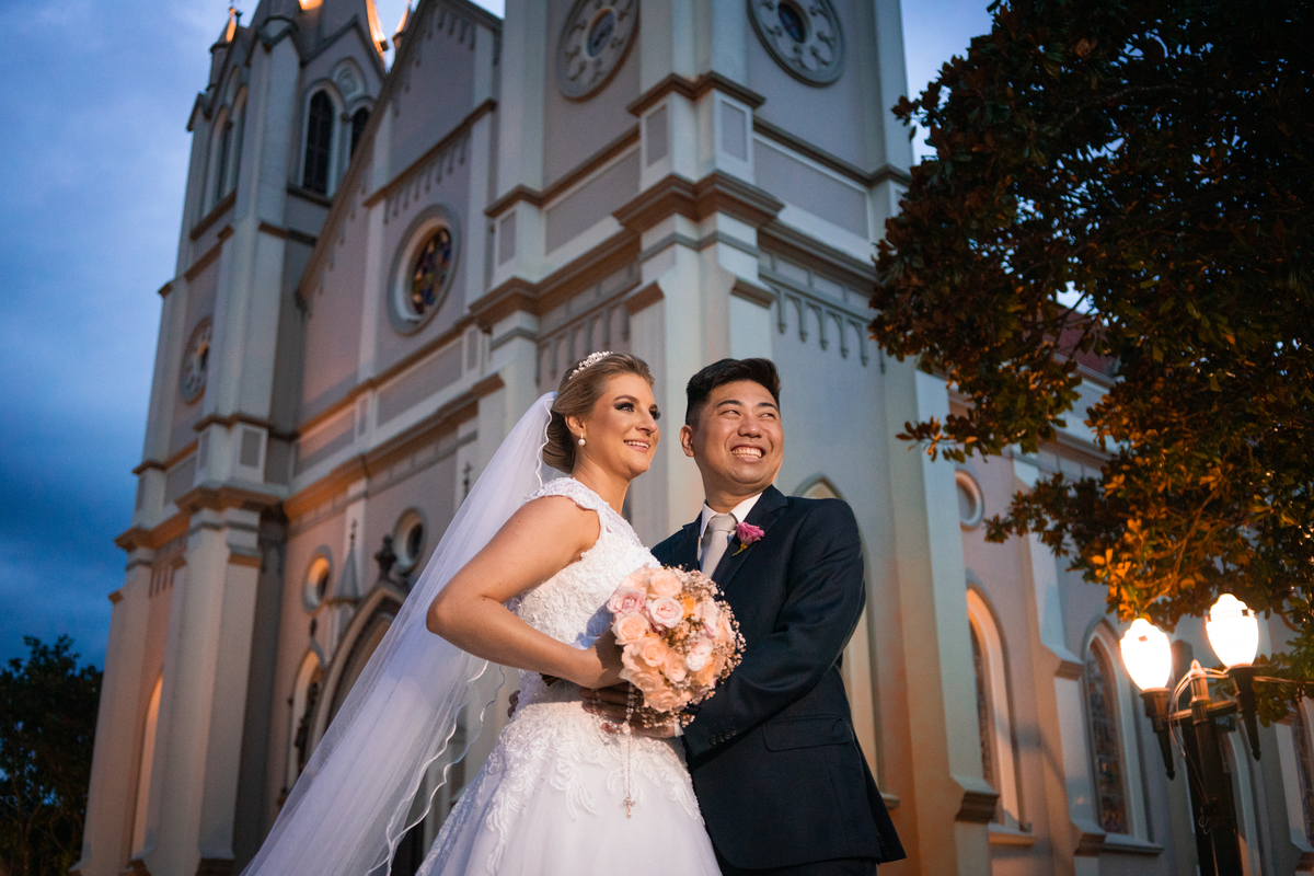 Casamento fotografado pelo fotógrafo Michel Druziki. Cerimônia de casamento dos noivos Denise e Marcelo foi realizada na igreja Matriz de Campo Largo. Noivos abraçados em frente à igreja após o casamento