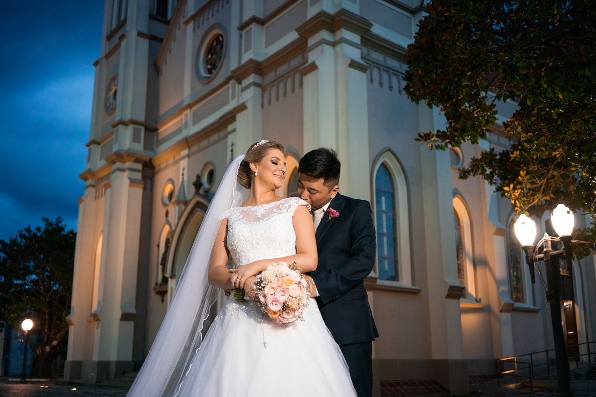 Casamento fotografado pelo fotógrafo Michel Druziki. Cerimônia de casamento dos noivos Denise e Marcelo foi realizada na igreja Matriz de Campo Largo. Noivos abraçados em frente à igreja após o casamento