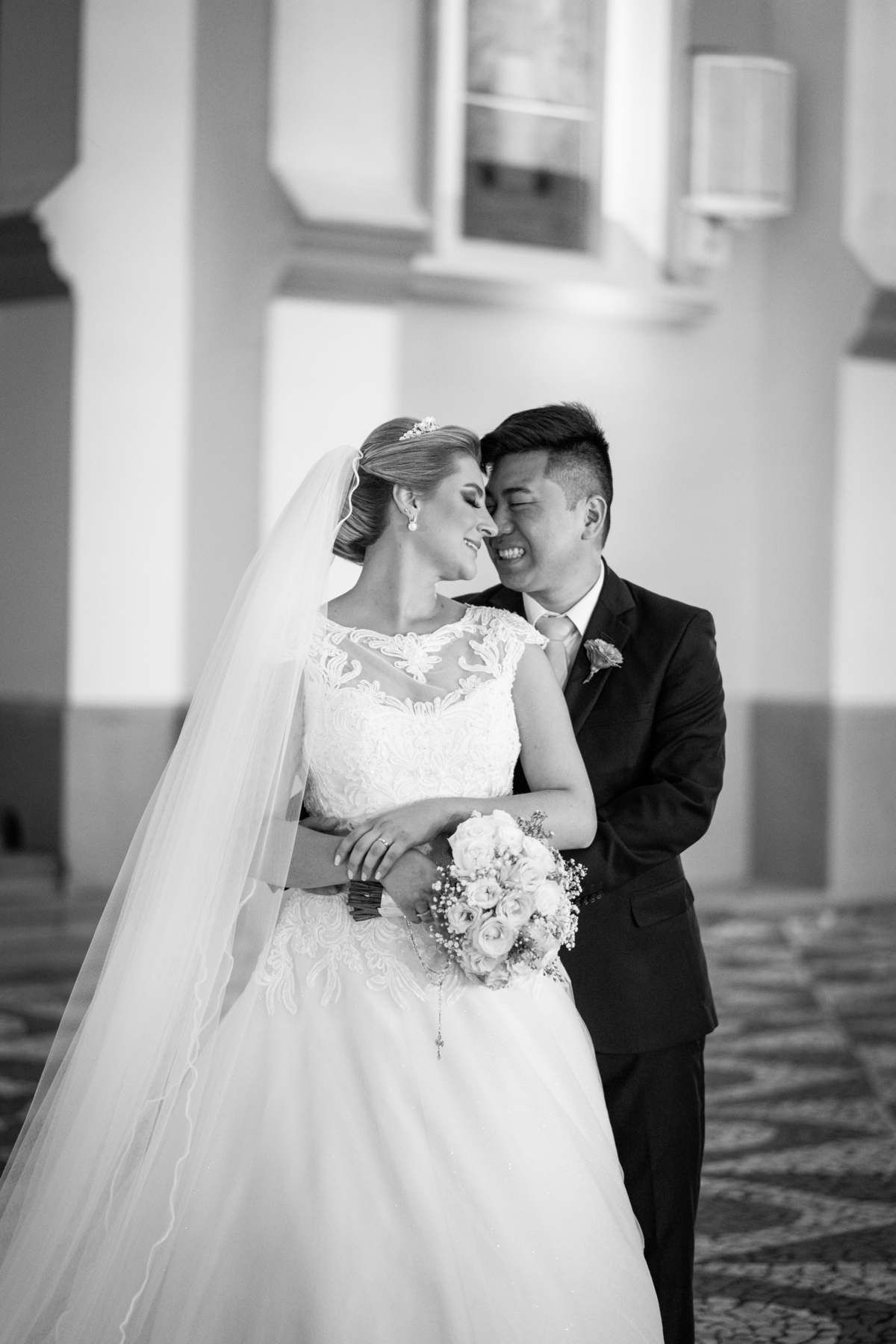 Casamento fotografado pelo fotógrafo Michel Druziki. Cerimônia de casamento dos noivos Denise e Marcelo foi realizada na igreja Matriz de Campo Largo. Noivos abraçados e sorrindo em frente à igreja após o casamento