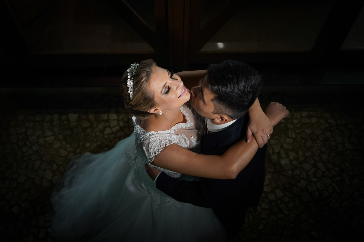Casamento fotografado pelo fotógrafo Michel Druziki. Cerimônia de casamento dos noivos Denise e Marcelo foi realizada na igreja Matriz de Campo Largo. Noivo dando beijo no queixo da noiva 