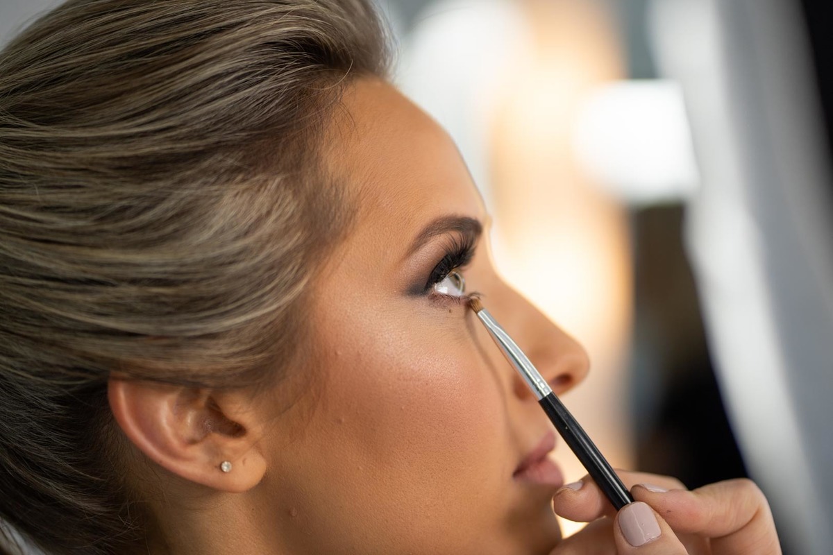 Melhor fotógrafo de Campo Largo e curitiba Michel Druziki. Making of da noiva Letícia. Noiva de cabelo preso e pincel esfumando o olho.