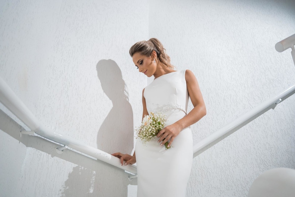 Melhor fotógrafo de Campo Largo e curitiba Michel Druziki. Making of da noiva Letícia. Noiva de cabelo preso encostada na escada com buquê de flores mosquitinho e lírio