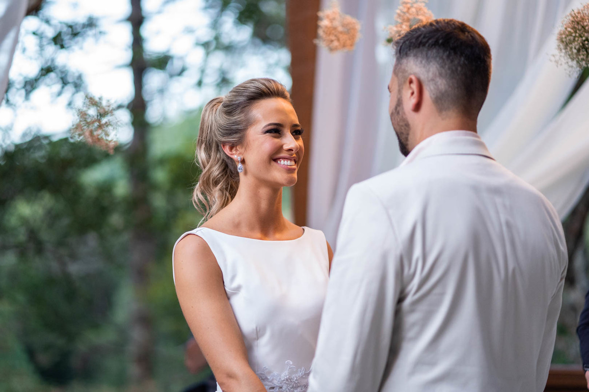 Melhor fotógrafo de Campo Largo e curitiba Michel Druziki. noivos de mãos dadas durante a cerimônia ao ar livre se olhando e sorrindo