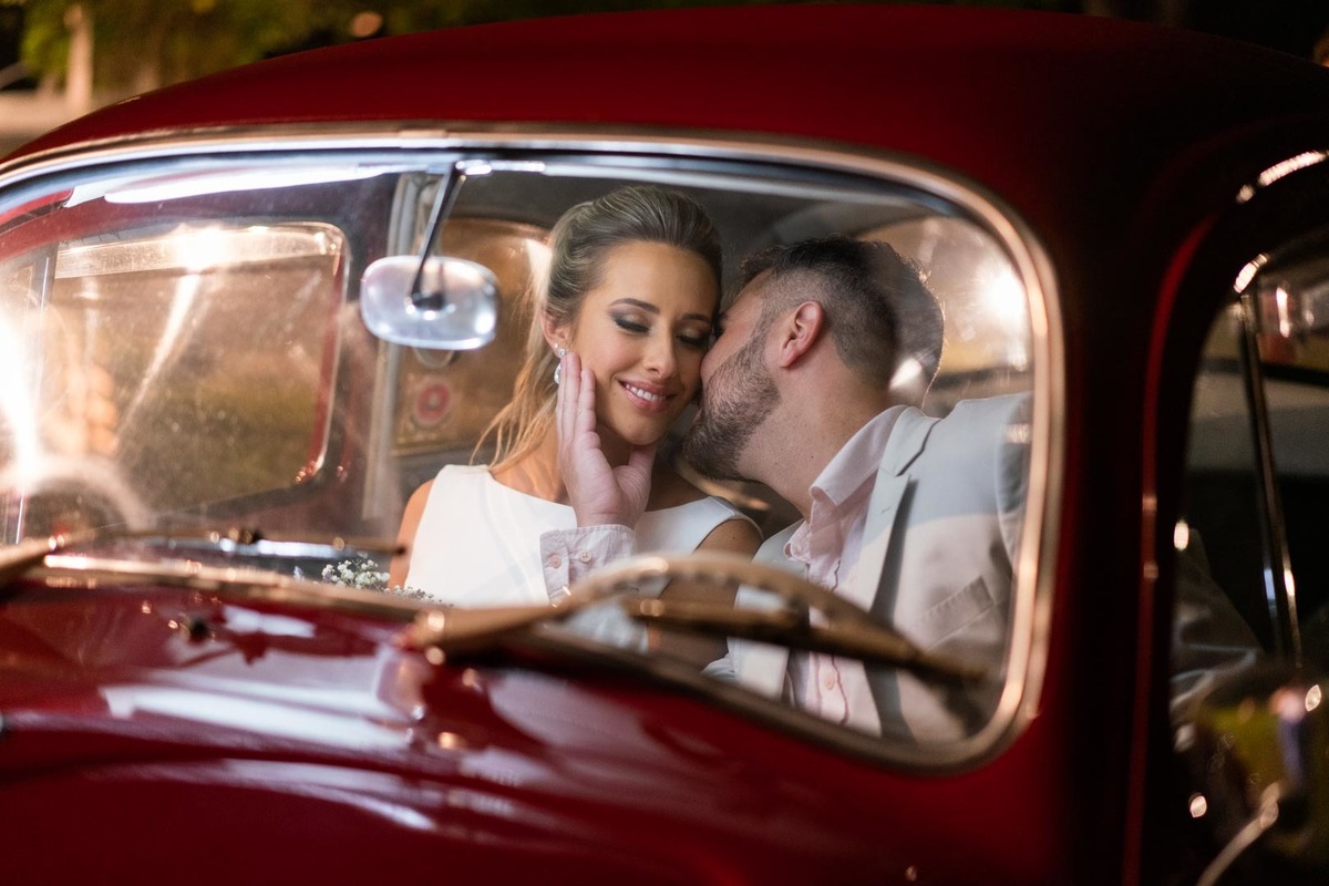 Melhor fotógrafo de Campo Largo e curitiba Michel Druziki. Noivo dando beijo no rosto da noiva dentro do fusca vermelho