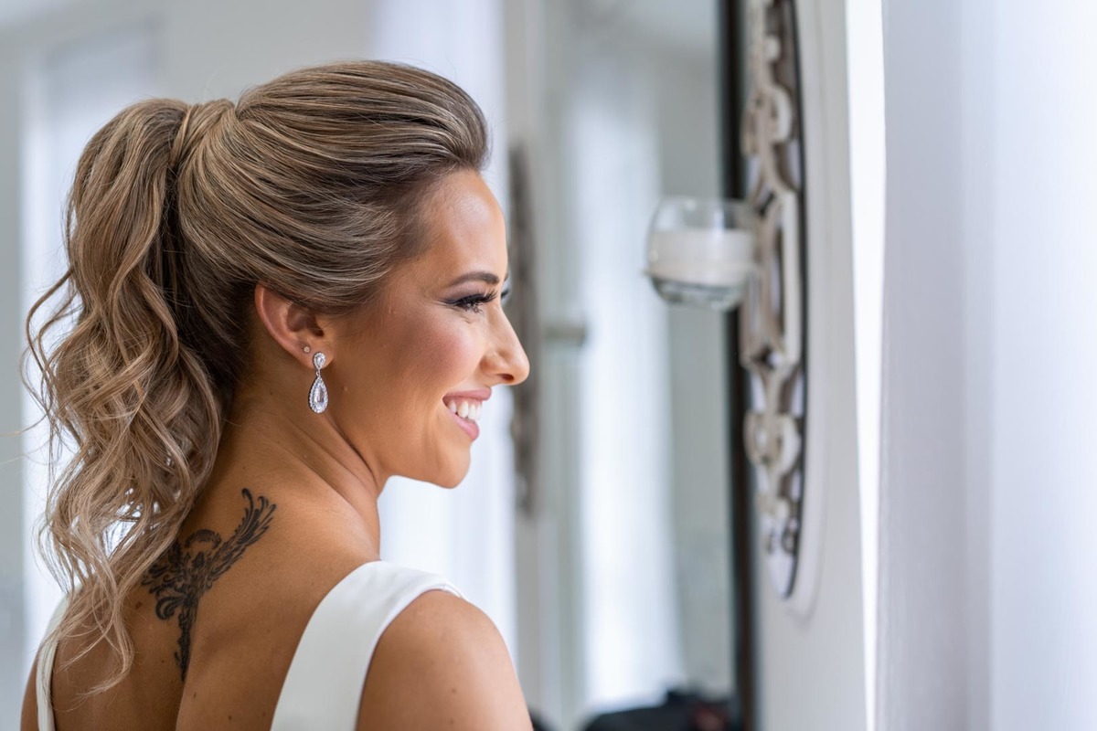 Melhor fotógrafo de Campo Largo e curitiba Michel Druziki. Making of da noiva Letícia. Noiva de cabelo preso sorrindo olhando na janela