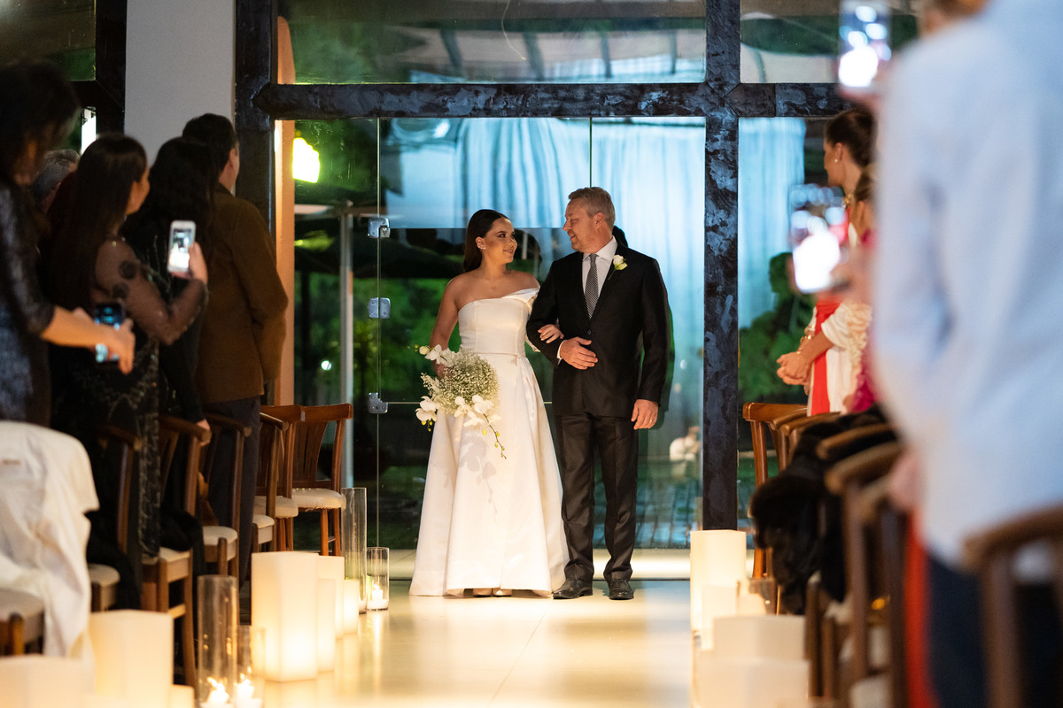 Fotografia de Casamento em Curitiba Rebeca e Vinicius no Magiiore Barigui. Entrada da noiva sorrindo com o pai. Fotografado pelo fotógrafo de casamento Michel Druziki