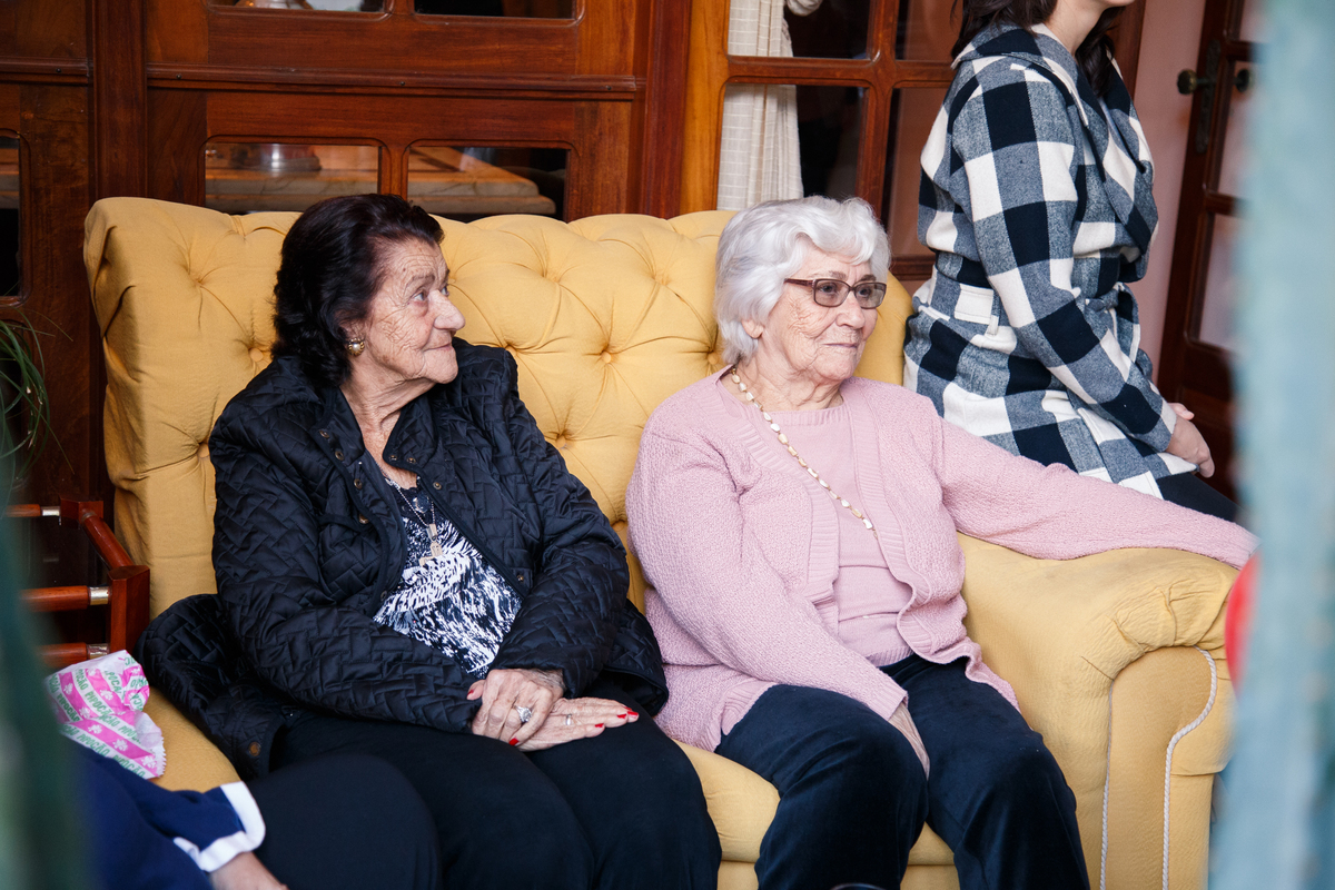 Duas bisavós sentadas no sofá em aniversário infantil de 1 ano da bisneta.