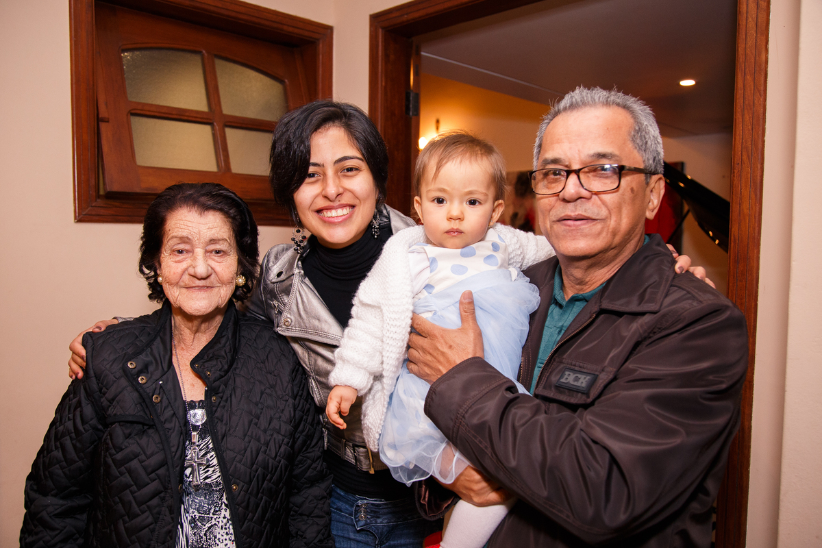 Bisavó, avô, mãe e a bebê posando para foto durante seu aniversário de 1 ano.