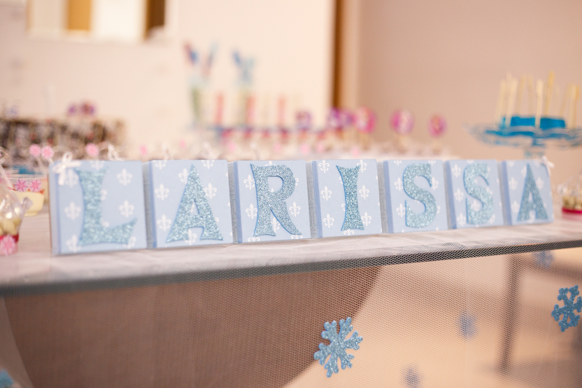 Decoração de aniversário infantil no tema Frozen, foco no nome da aniversariante.