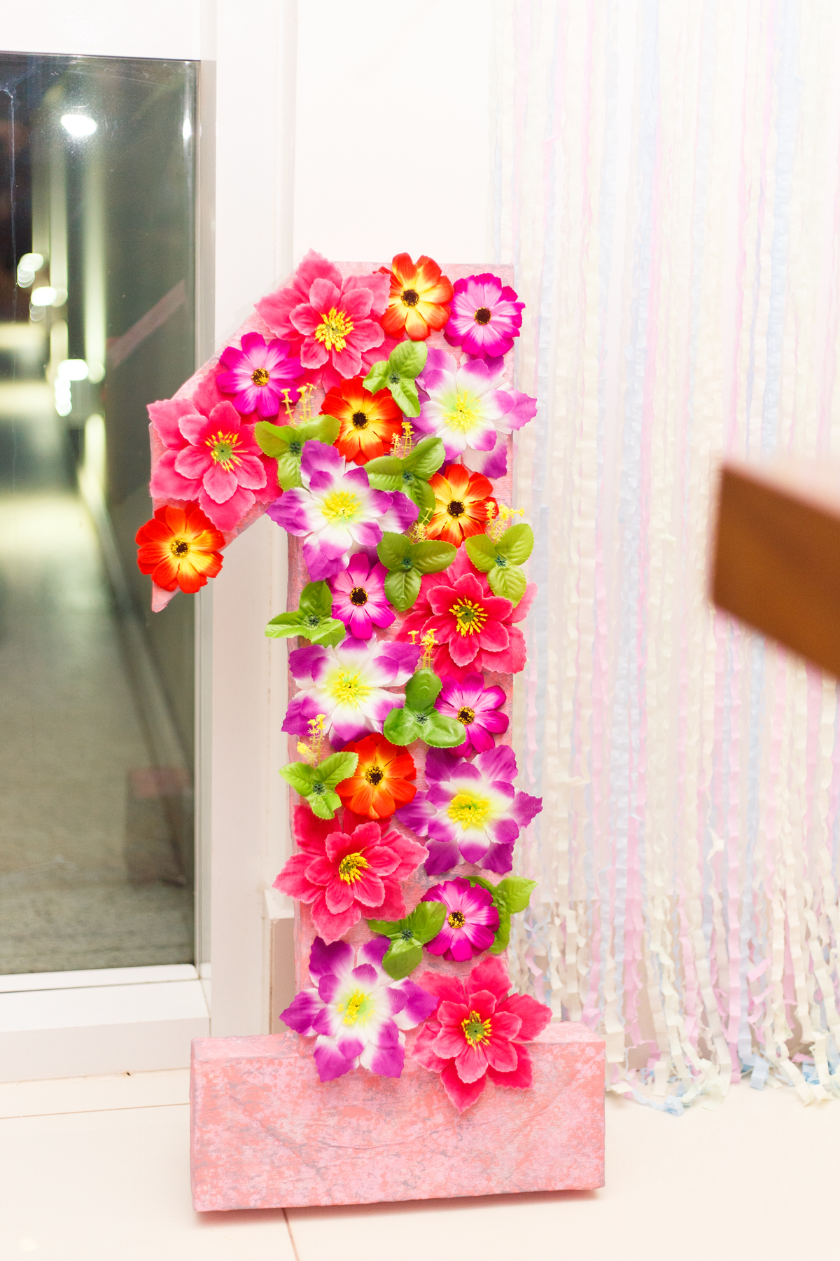 Número 1 todo enfeitado com flores parte da decoração de aniversário infantil.