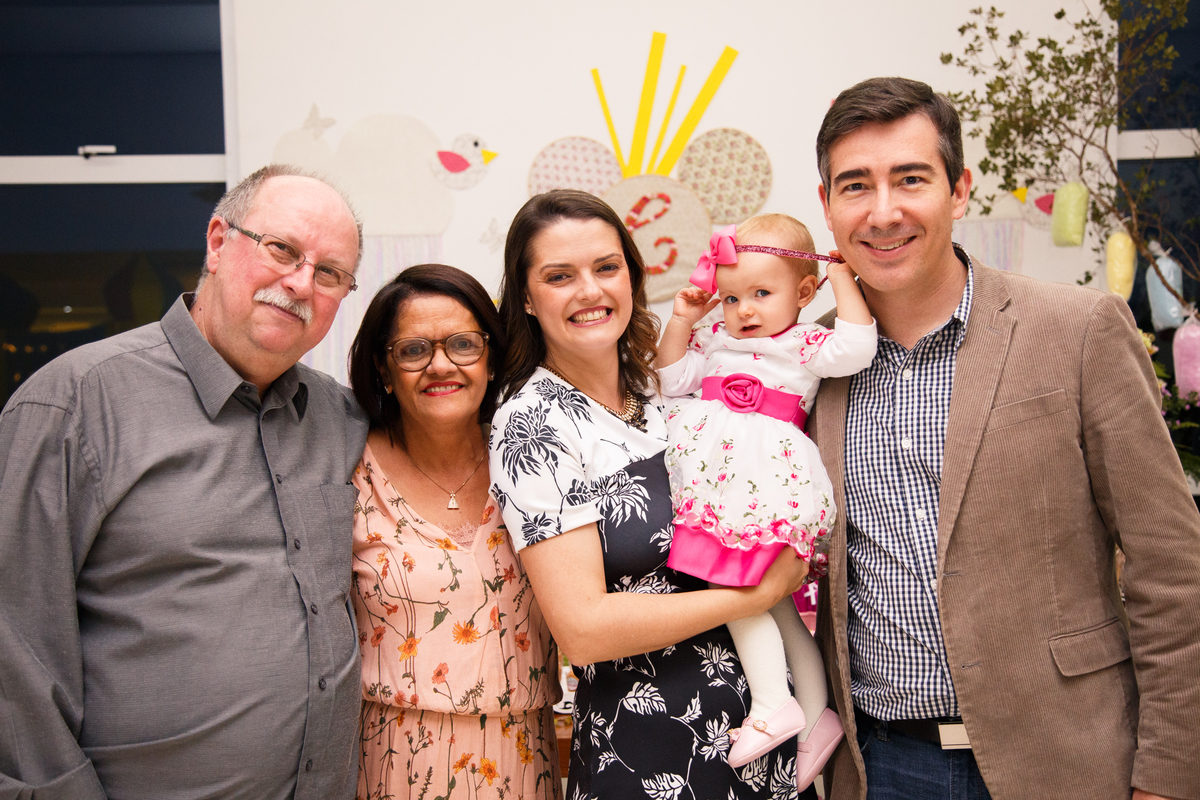 Pais com seu bebê no colo posando para foto junto com os avós maternos.