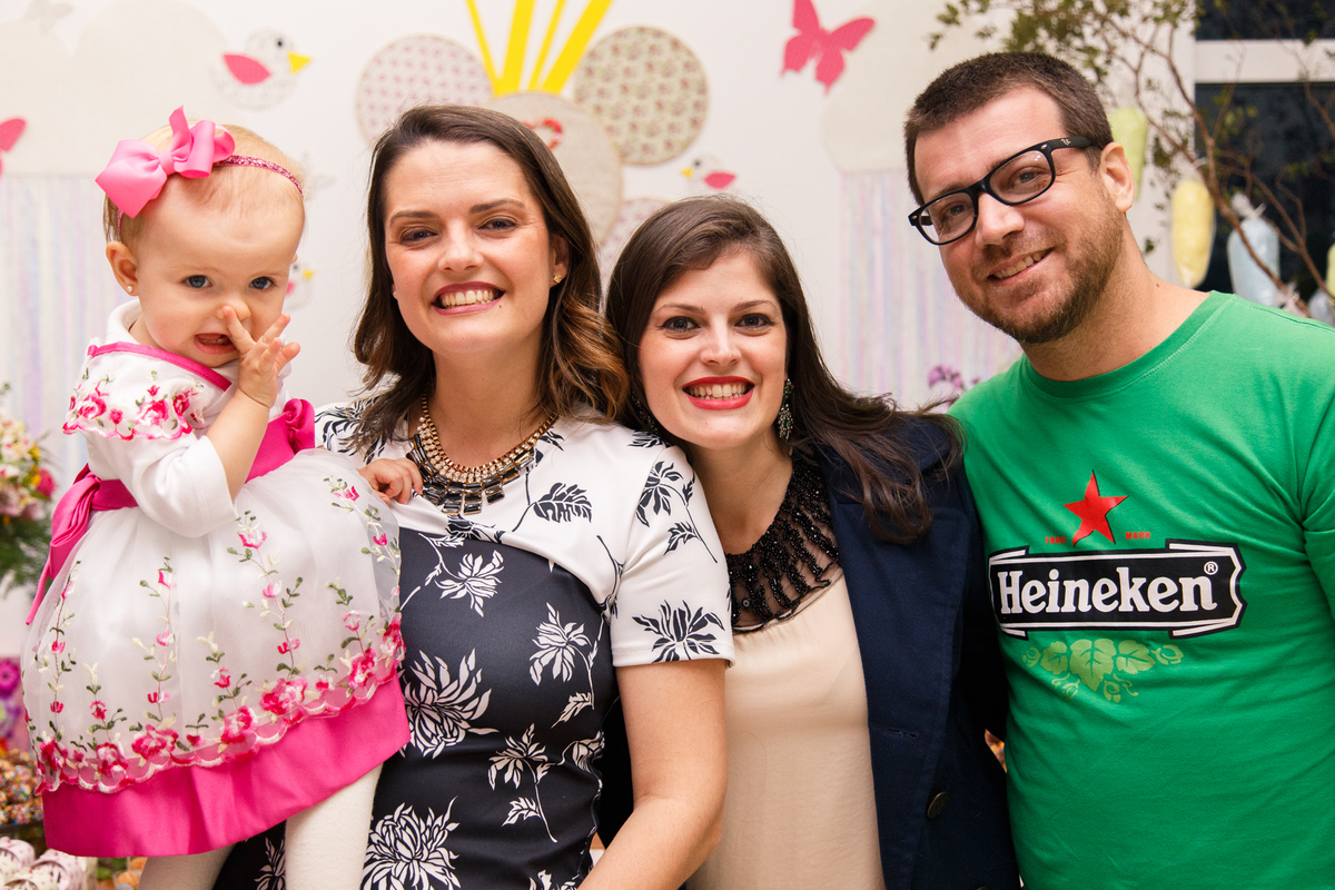 Mãe com sua bebê no colo posando para foto junto com sua irmã e cunhado.