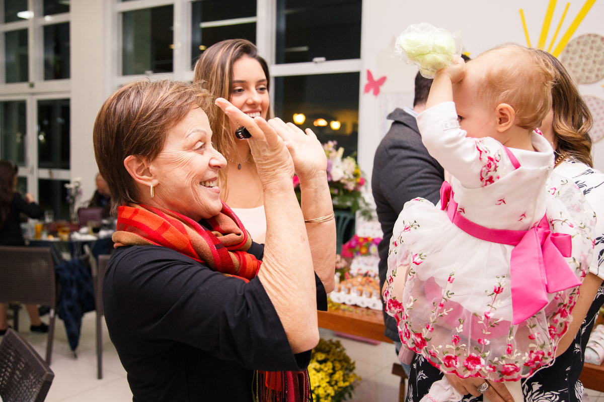 Criança aniversariante brincando com uma convidada de bater palminhas.