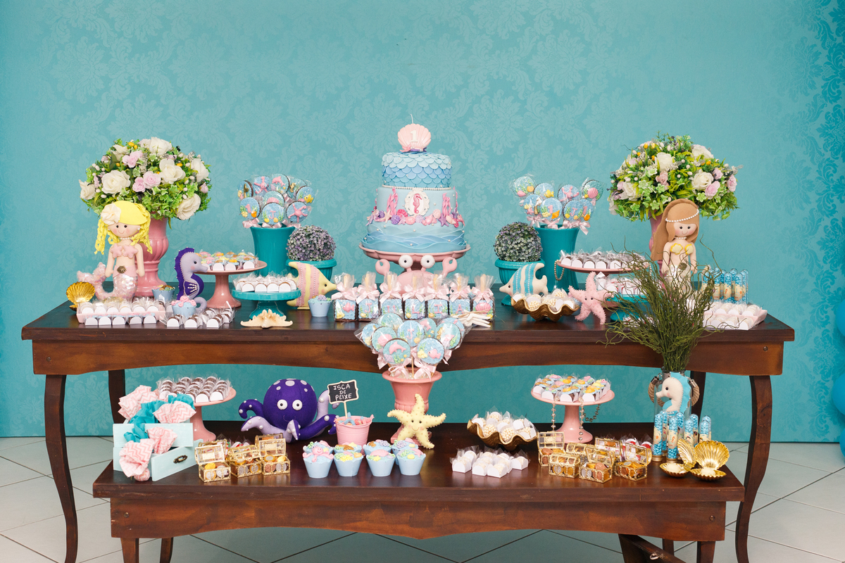 Detalhe mais próximo da mesa do bolo em aniversário infantil de 1 ano no tema sereia e fundo do mar.