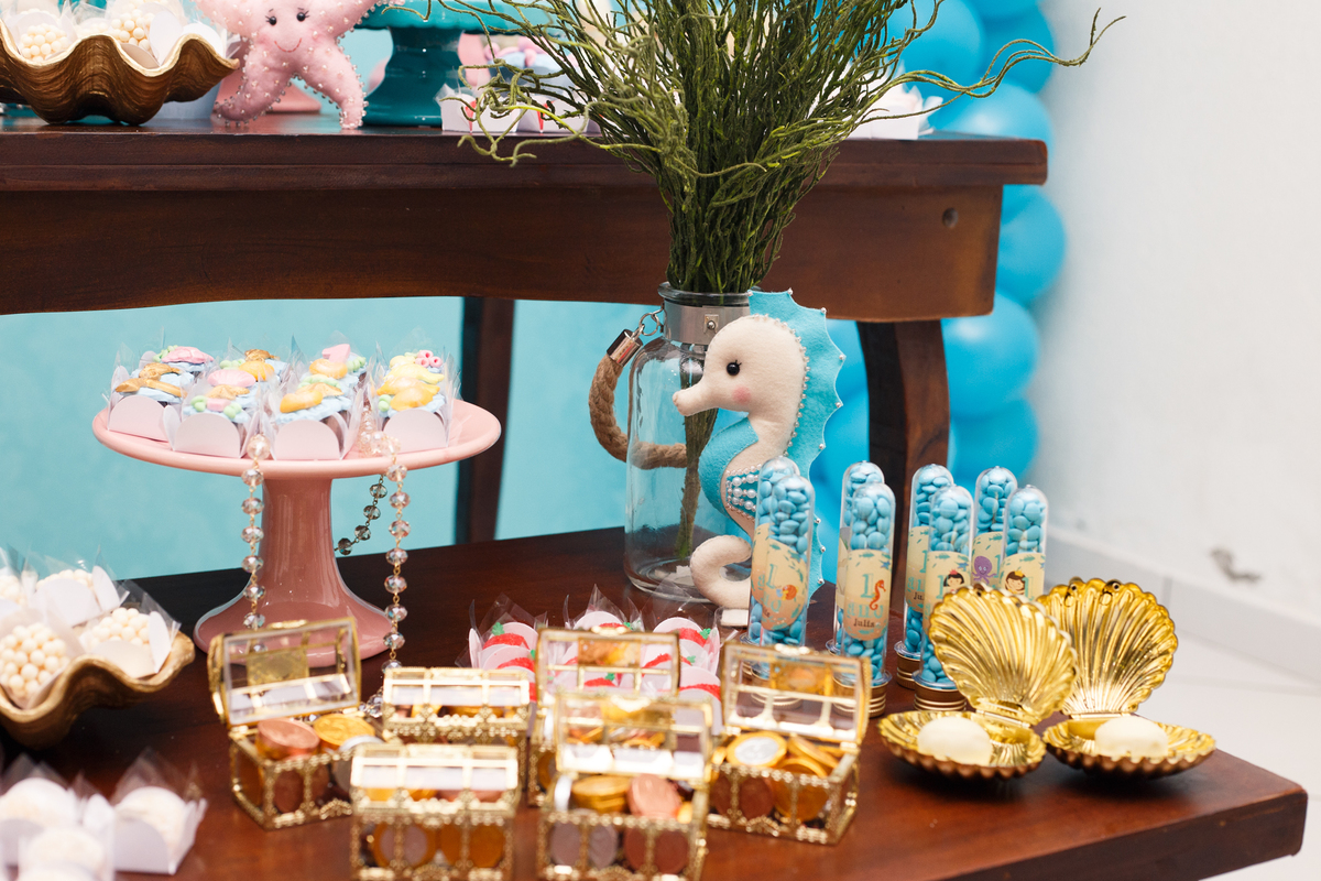 Detalhe de cavalo marinho e baús do tesouro na decoração de aniversário infantil no tema fundo do mar.