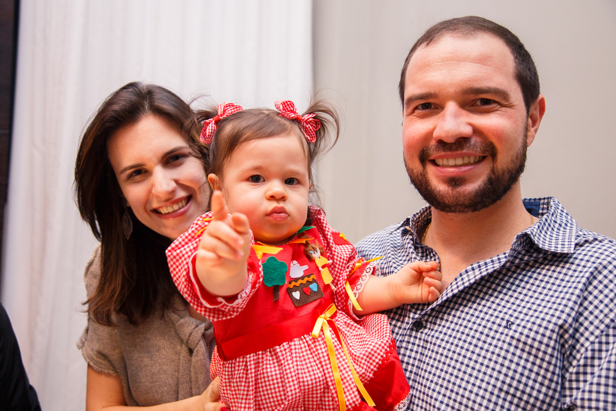 Bebê de 1 ano com seus pais em sua festa de aniversário.