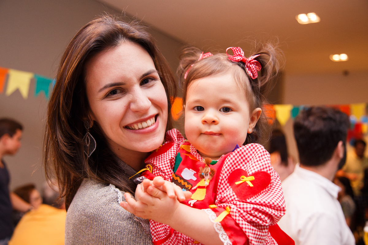 Bebê aniversariante com sua mãe durante festa de aniversário infantil.