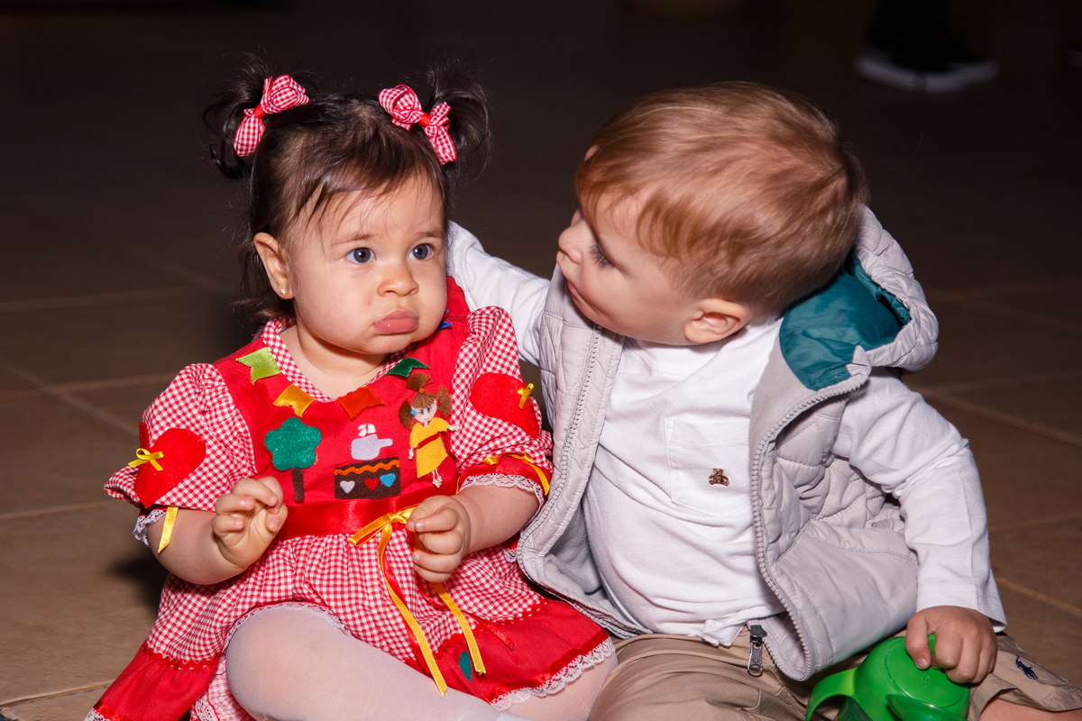 Bebê aniversariante ganhando um carinho na cabeça de seu priminho durante a festa de aniversário.