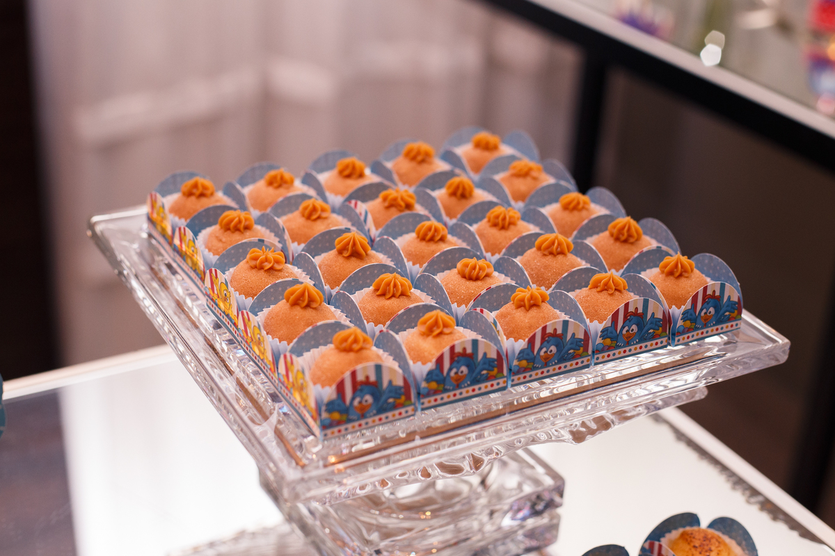 Detalhe de doces na mesa do bolo em aniversário infantil no tema galinha pintadinha.